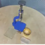 Adjustable glass bottle cutting tool set with metal stand, cutter heads, glass sheet, and circular glass piece for precise bottle cutting.