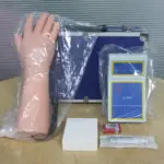 Electronic IV training hand kit with lifelike arm model, control unit, tubing, and accessories for nursing venipuncture and injection practice.
